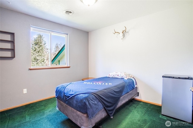 bedroom with carpet floors, baseboards, visible vents, and freestanding refrigerator