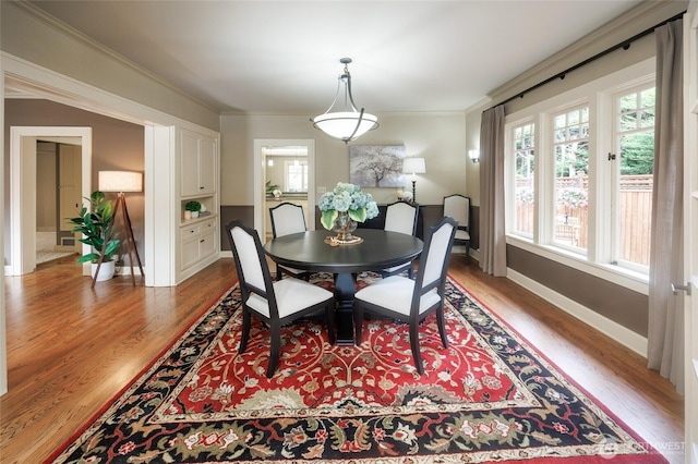 dining area featuring ornamental molding, wood finished floors, and baseboards