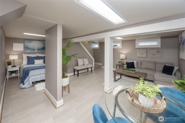 living area with stairway, light wood-type flooring, and baseboards