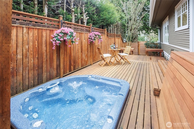 wooden terrace featuring hot tub deck surround