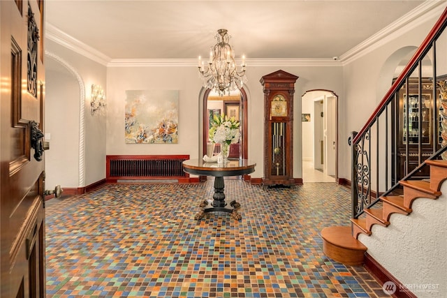 foyer entrance with stairway, baseboards, arched walkways, and crown molding