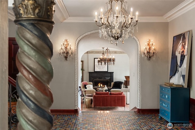 hallway with arched walkways, ornamental molding, a chandelier, and baseboards