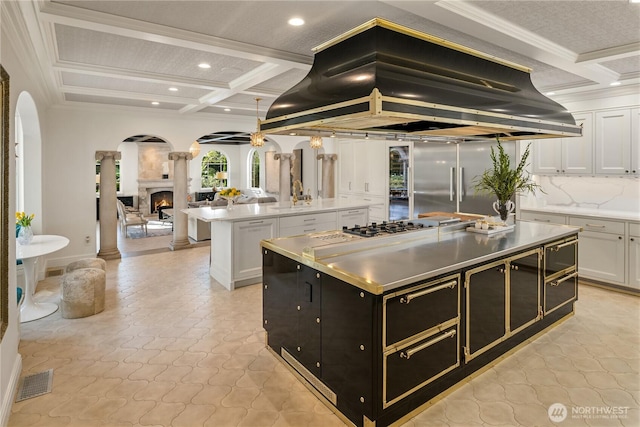 kitchen featuring arched walkways, a kitchen island, island range hood, dark cabinets, and coffered ceiling