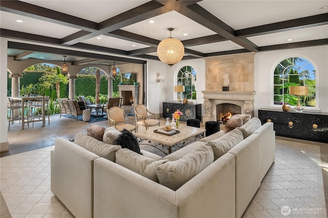 living area featuring a wealth of natural light, coffered ceiling, a fireplace, and beamed ceiling