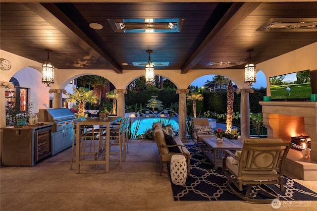 view of patio with an outdoor kitchen, a grill, outdoor dining area, and a ceiling fan