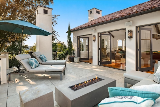 view of patio / terrace with an outdoor living space with a fire pit