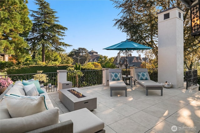 view of patio with an outdoor living space with a fire pit