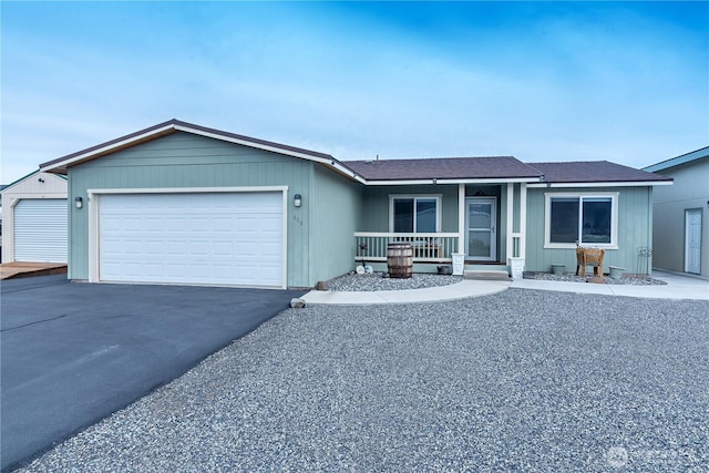 ranch-style home with an attached garage, covered porch, and driveway