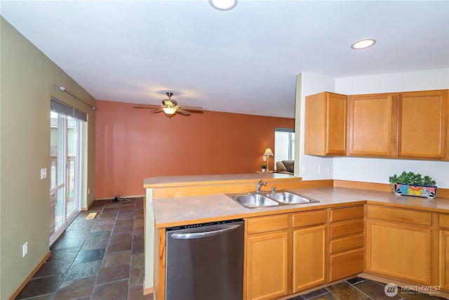 kitchen featuring stone tile floors, a ceiling fan, a peninsula, a sink, and stainless steel dishwasher