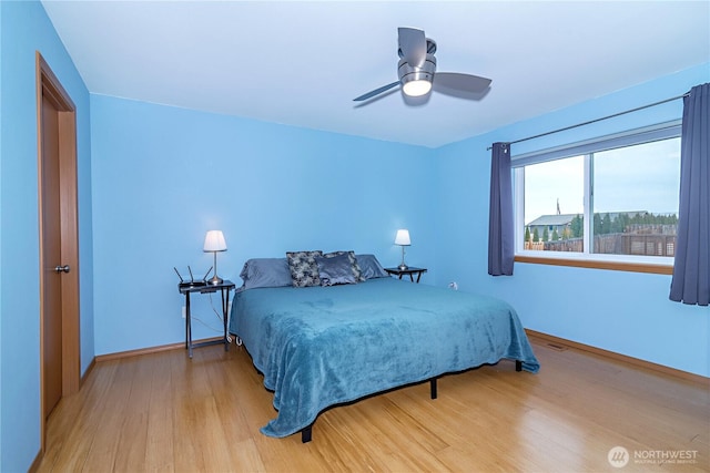 bedroom featuring visible vents, wood finished floors, baseboards, and ceiling fan