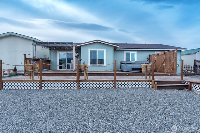 view of front of house featuring a deck, a pergola, and a hot tub