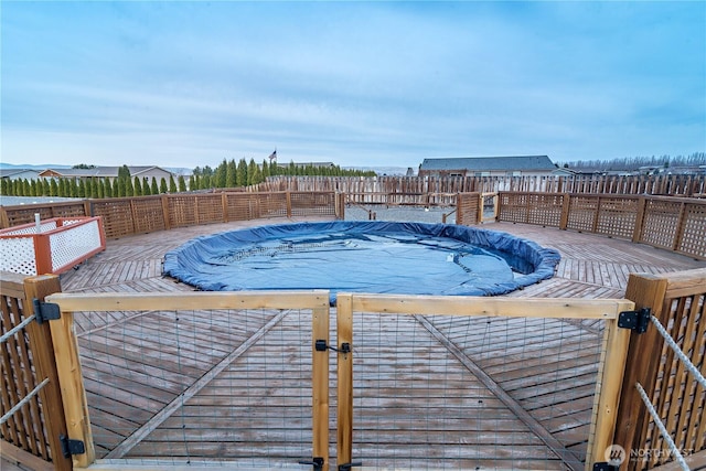 view of swimming pool featuring a fenced in pool, a wooden deck, and a fenced backyard