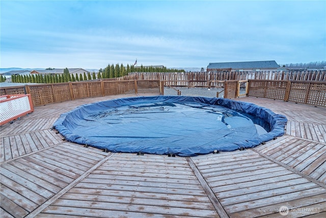 view of pool featuring a deck, a fenced in pool, and a fenced backyard