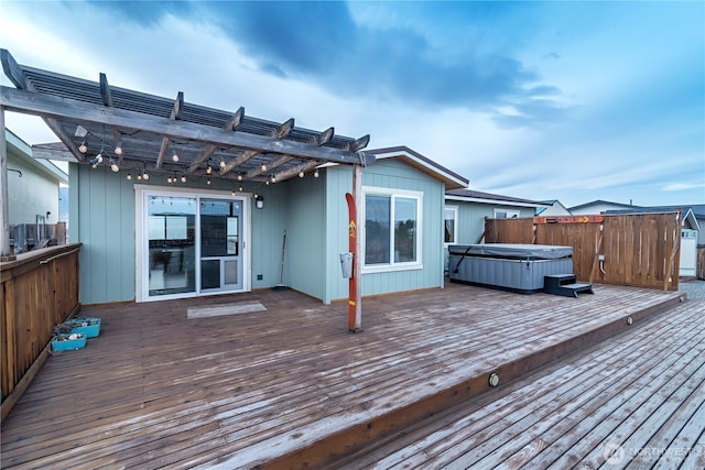 wooden terrace featuring a hot tub and a pergola