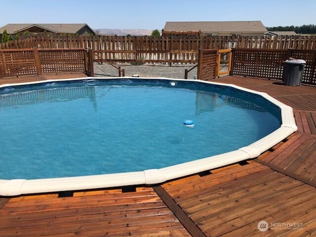 view of pool with a wooden deck and fence