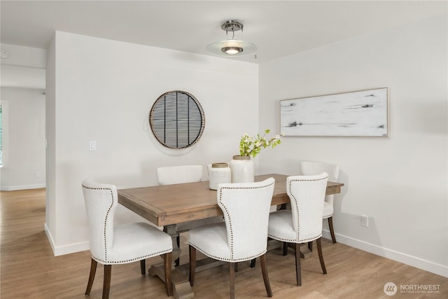 dining room with baseboards and wood finished floors