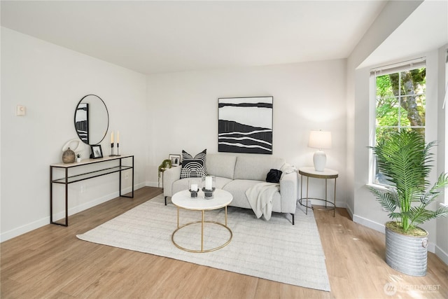 living area with baseboards and wood finished floors