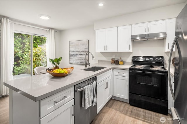 kitchen with light countertops, appliances with stainless steel finishes, a sink, a peninsula, and under cabinet range hood