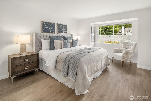 bedroom with baseboards and wood finished floors