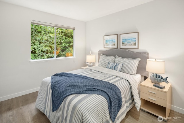 bedroom with baseboards and wood finished floors