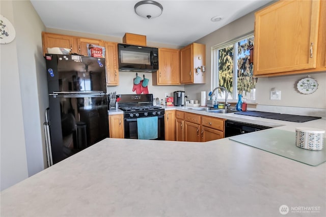 kitchen featuring black appliances, a sink, and light countertops