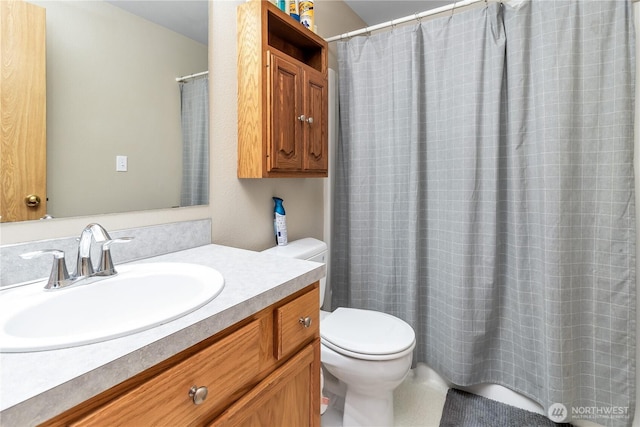 bathroom with curtained shower, vanity, and toilet