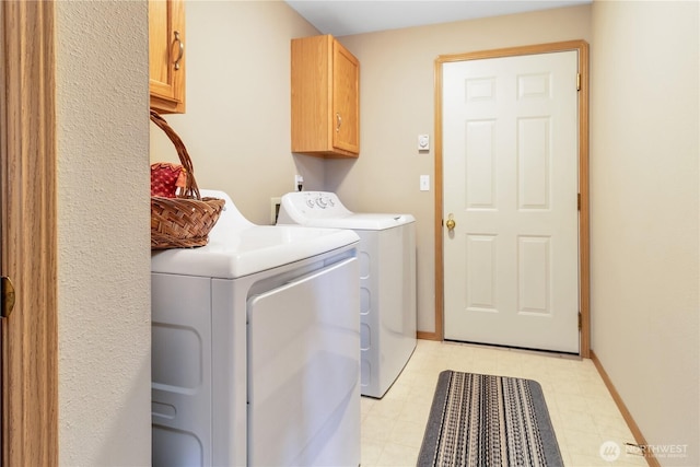 clothes washing area featuring light floors, washing machine and dryer, cabinet space, and baseboards