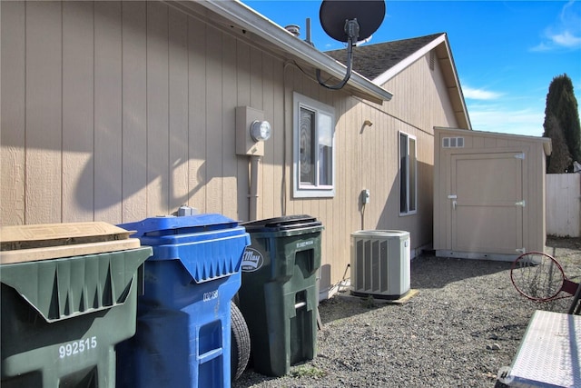 view of side of property with central AC, an outdoor structure, and a storage unit