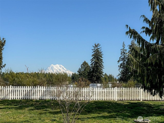 view of yard featuring fence and a mountain view