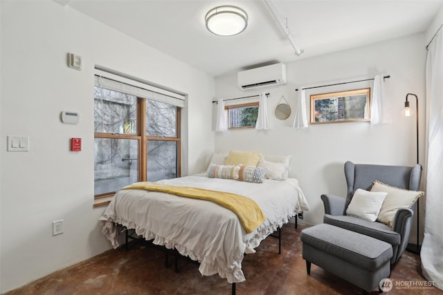 bedroom featuring finished concrete flooring and a wall mounted AC