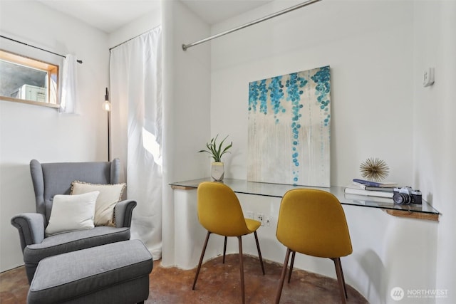 living area featuring concrete floors and built in desk