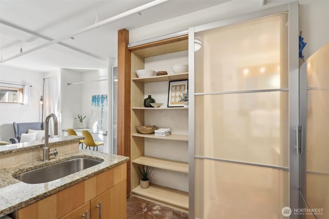 kitchen featuring light stone countertops and a sink