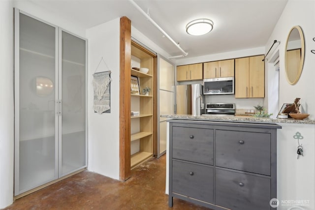 kitchen featuring light brown cabinetry, concrete flooring, gray cabinets, a peninsula, and stainless steel appliances