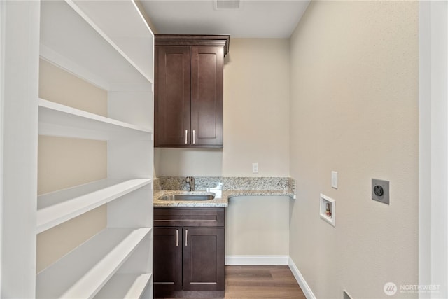 laundry room with dark wood-style floors, cabinet space, a sink, washer hookup, and electric dryer hookup