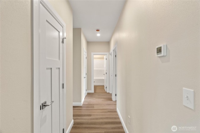 hallway featuring baseboards and wood finished floors