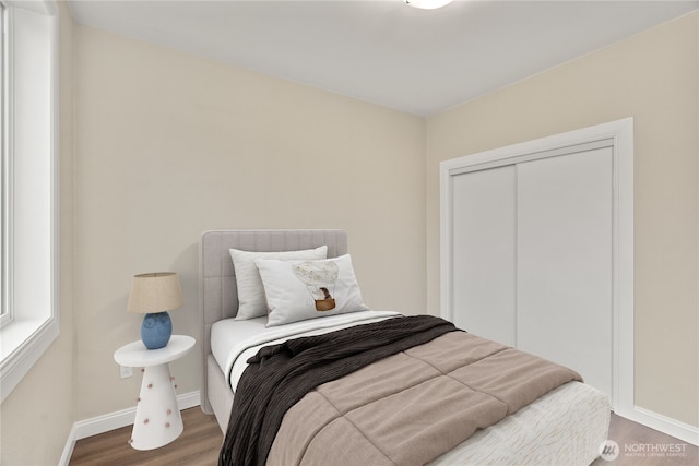 bedroom featuring a closet, baseboards, and wood finished floors