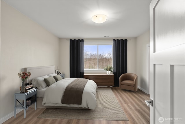 bedroom featuring light wood-style flooring and baseboards