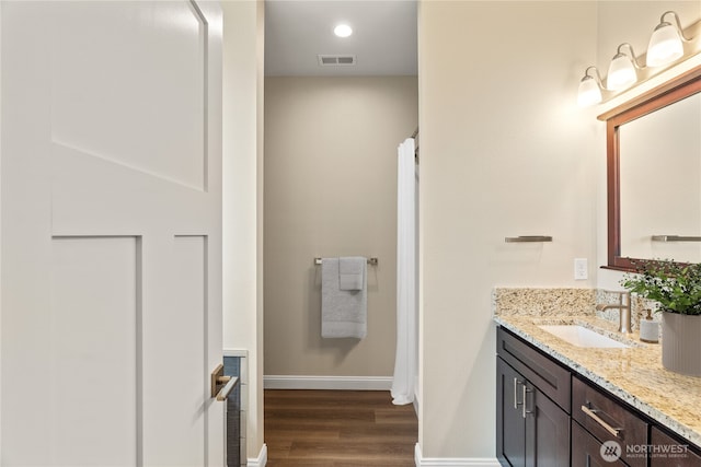 full bathroom featuring vanity, wood finished floors, visible vents, baseboards, and recessed lighting