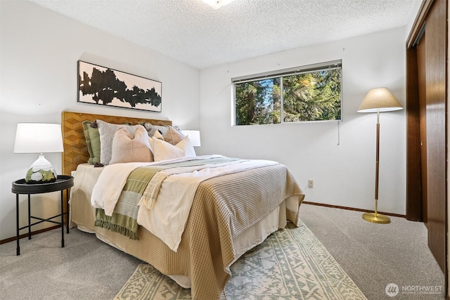 carpeted bedroom with baseboards and a textured ceiling