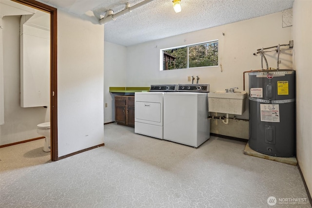 laundry area featuring independent washer and dryer, a sink, a textured ceiling, water heater, and laundry area