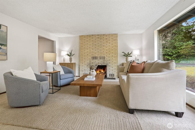 living area featuring plenty of natural light, a textured ceiling, carpet floors, and a fireplace