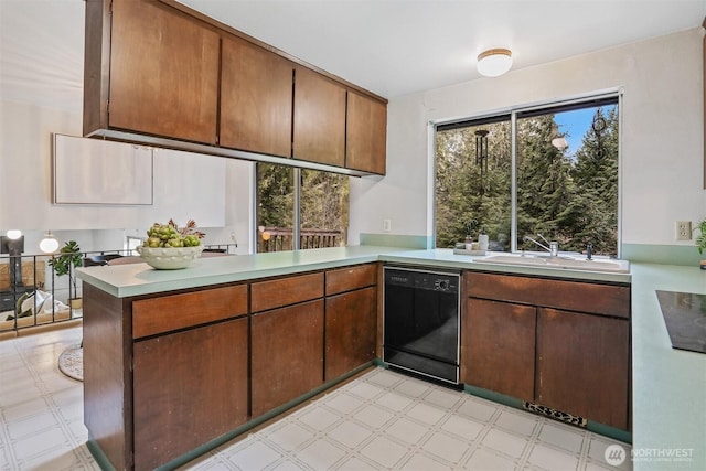 kitchen featuring a sink, light floors, black appliances, and a peninsula