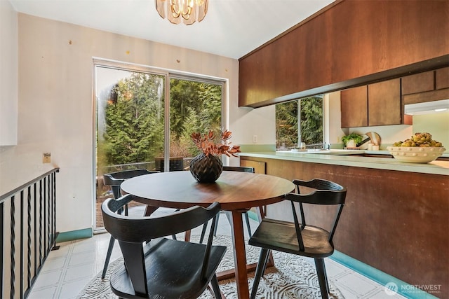 dining area with light floors and a chandelier