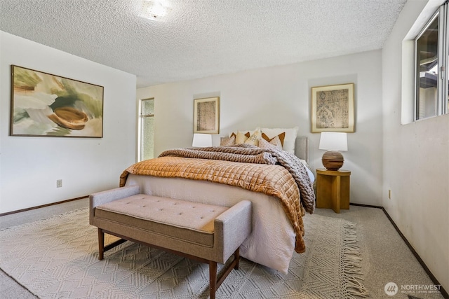 carpeted bedroom featuring baseboards and a textured ceiling