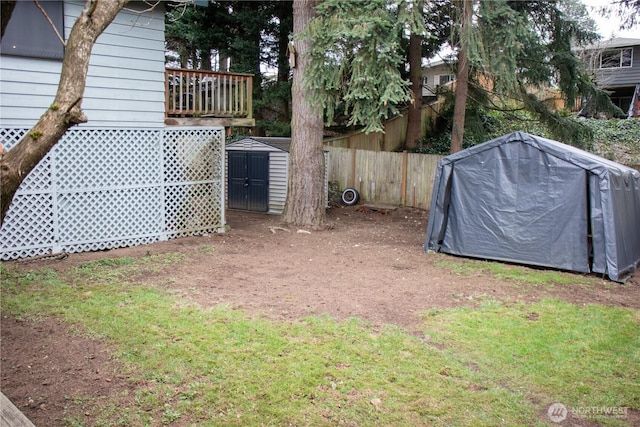 view of yard featuring an outdoor structure, fence, and a storage unit