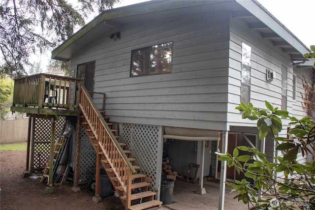 back of property featuring stairway, a wooden deck, and fence