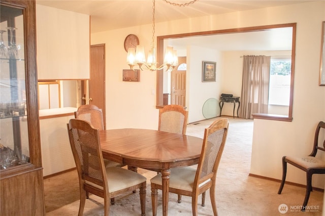 dining space featuring light carpet, an inviting chandelier, and baseboards