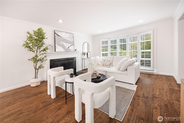 living area with a fireplace with flush hearth, crown molding, baseboards, and dark wood-style flooring