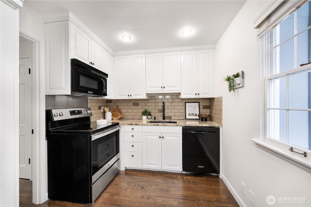 kitchen featuring decorative backsplash, white cabinetry, a sink, and black appliances