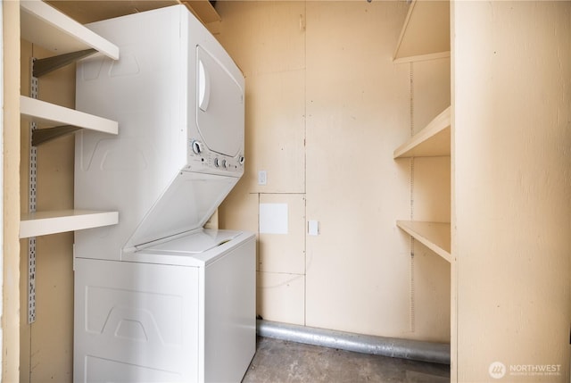 laundry area featuring stacked washer and clothes dryer and laundry area